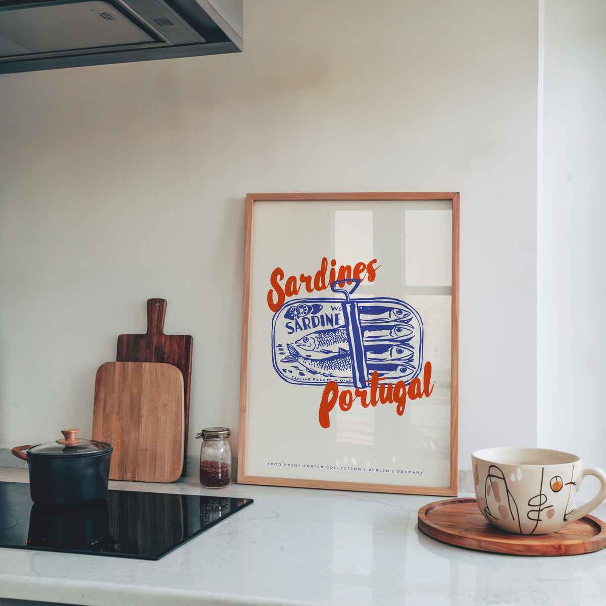 Blue sardine tin print in a pine frame on a marble kitchen counter