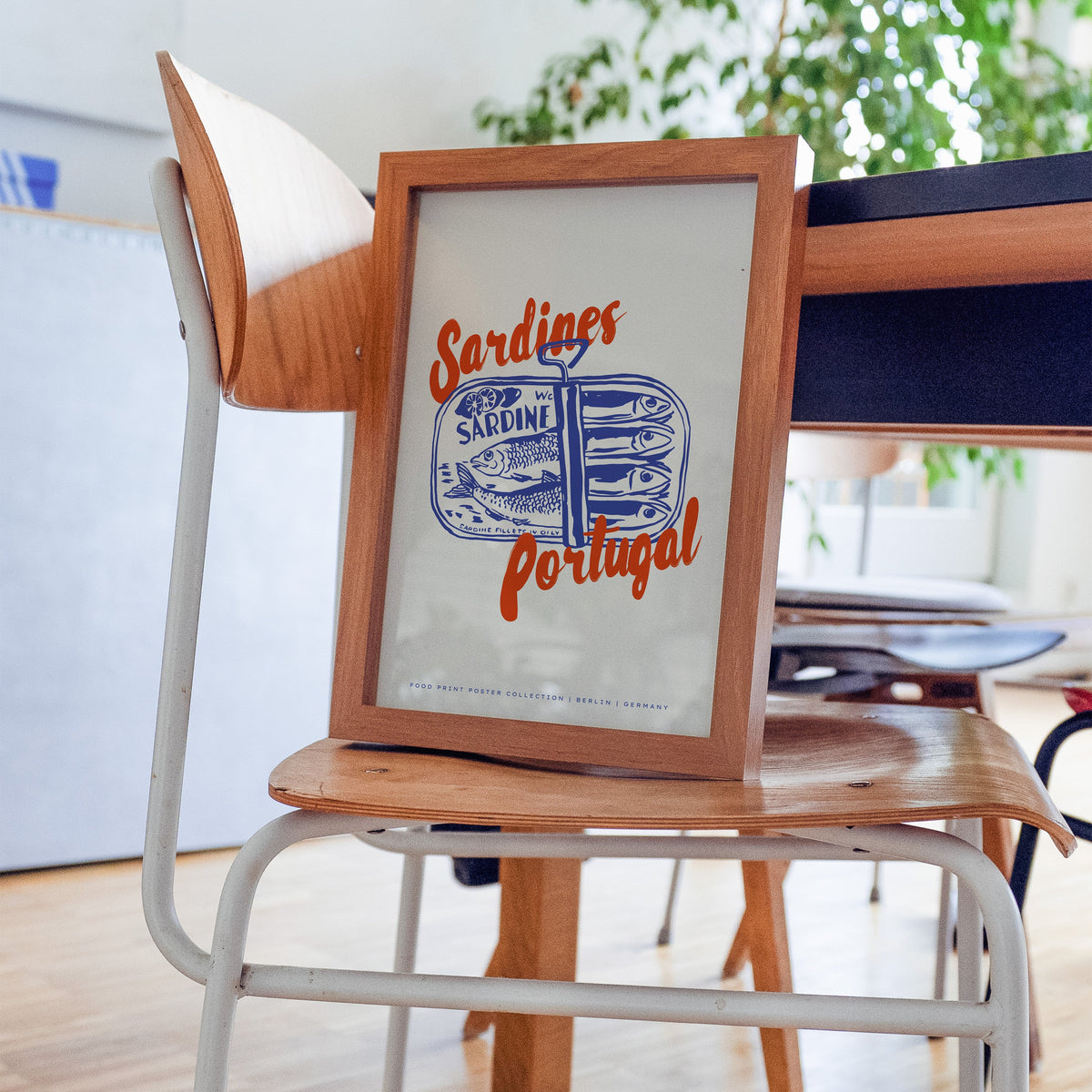 Blue sardine tin print in a walnut frame on a bentwood chair