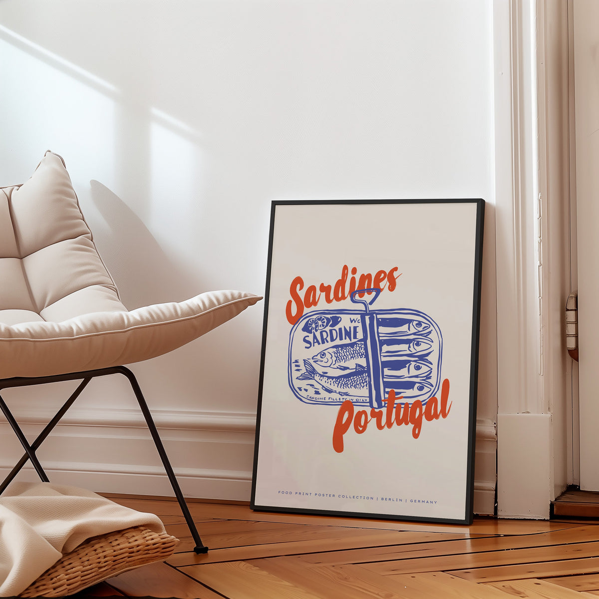 Blue sardine tin print in a black frame on a parquet floor