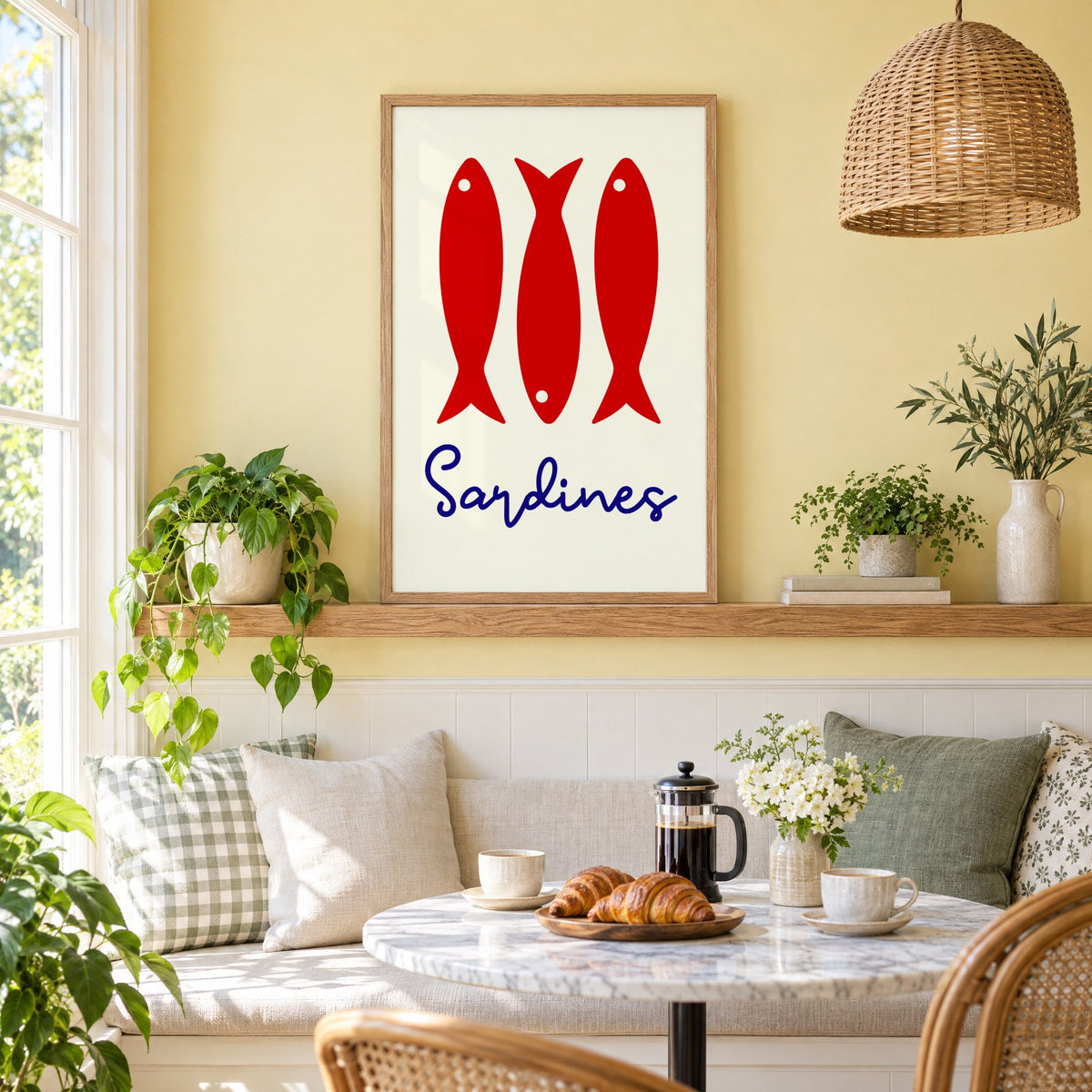 Three red sardines print in an oak frame on a picture ledge above a sunny breakfast nook