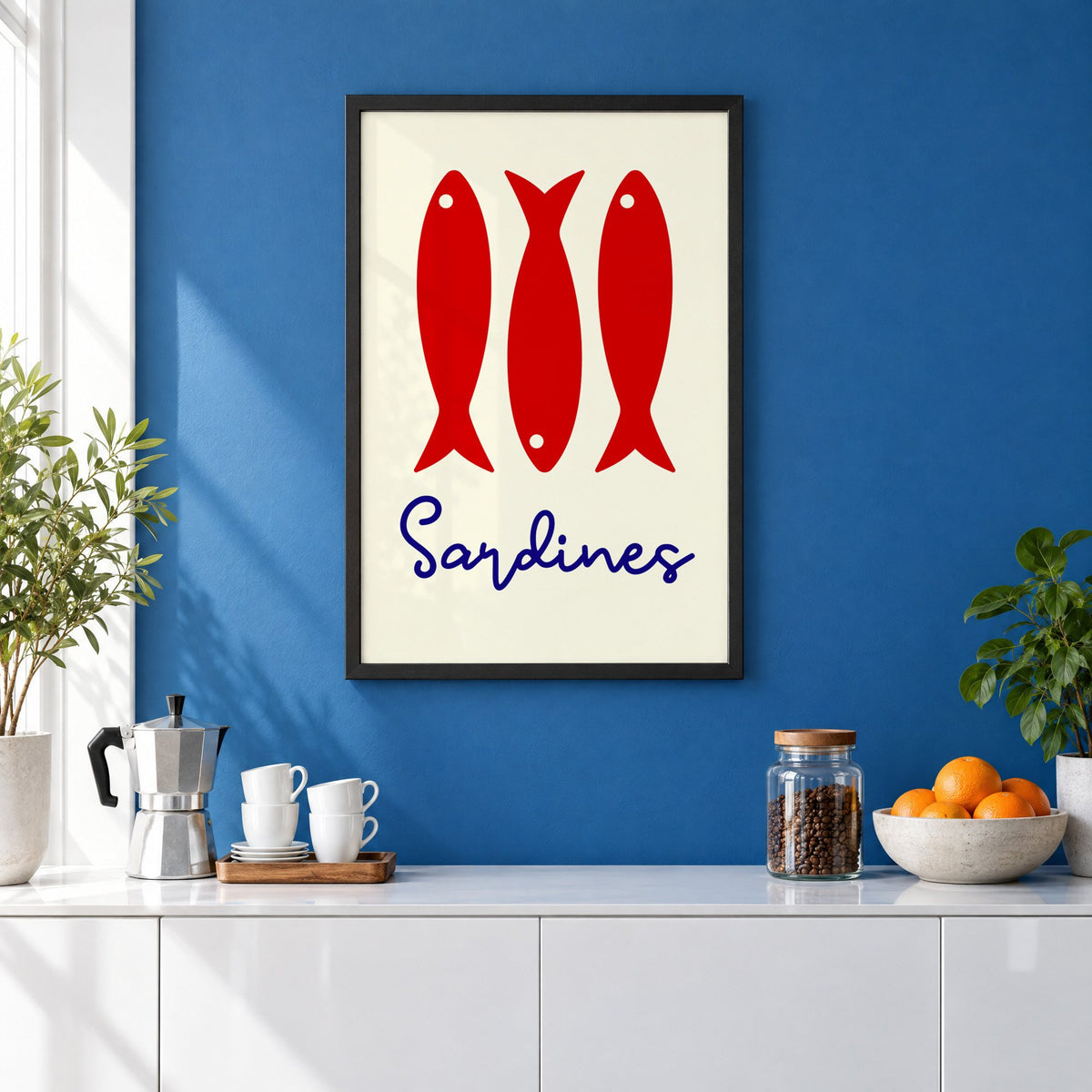 Three red sardines print in a black frame on a cobalt blue wall above a coffee station