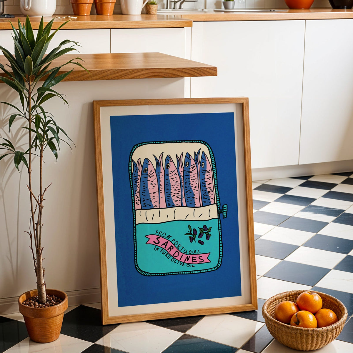 Blue sardine tin print in an oak frame by a kitchen island and checkered floor