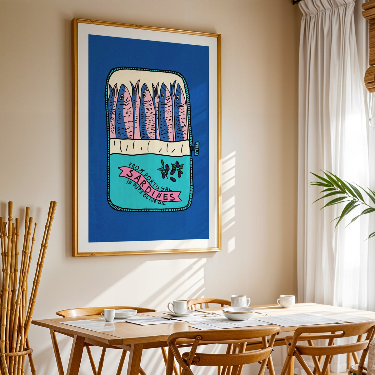 Blue sardine tin print in a gold frame above a sunlit breakfast table