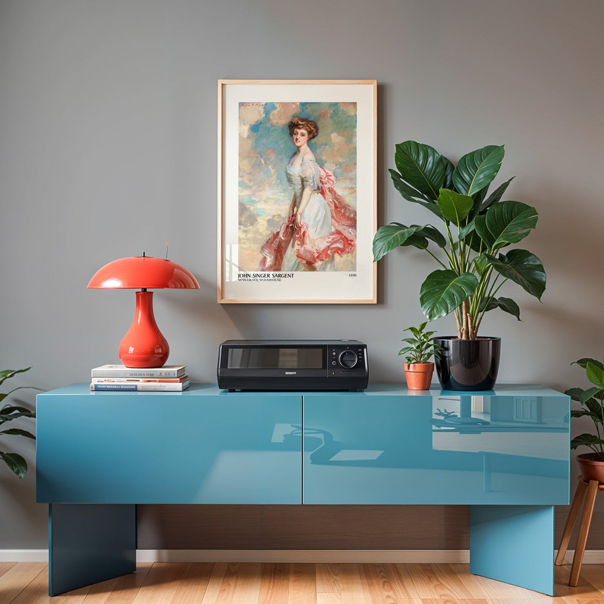 Sargent portrait print in an oak frame above a teal sideboard with a red lamp
