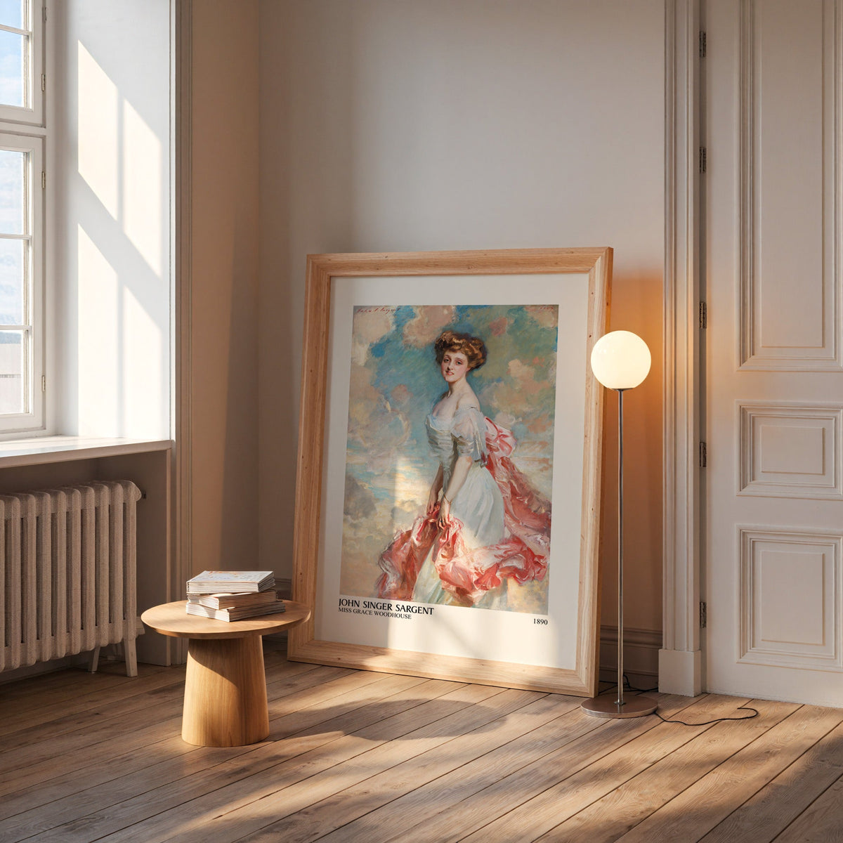 Grace Woodhouse print in a wide pine frame leaning by a sunlit window