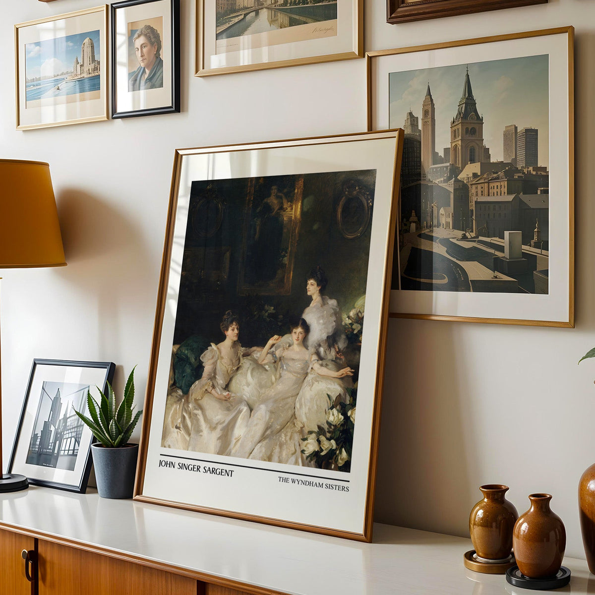 Victorian group portrait print shown in a gold frame leaning on a sideboard in a gallery wall