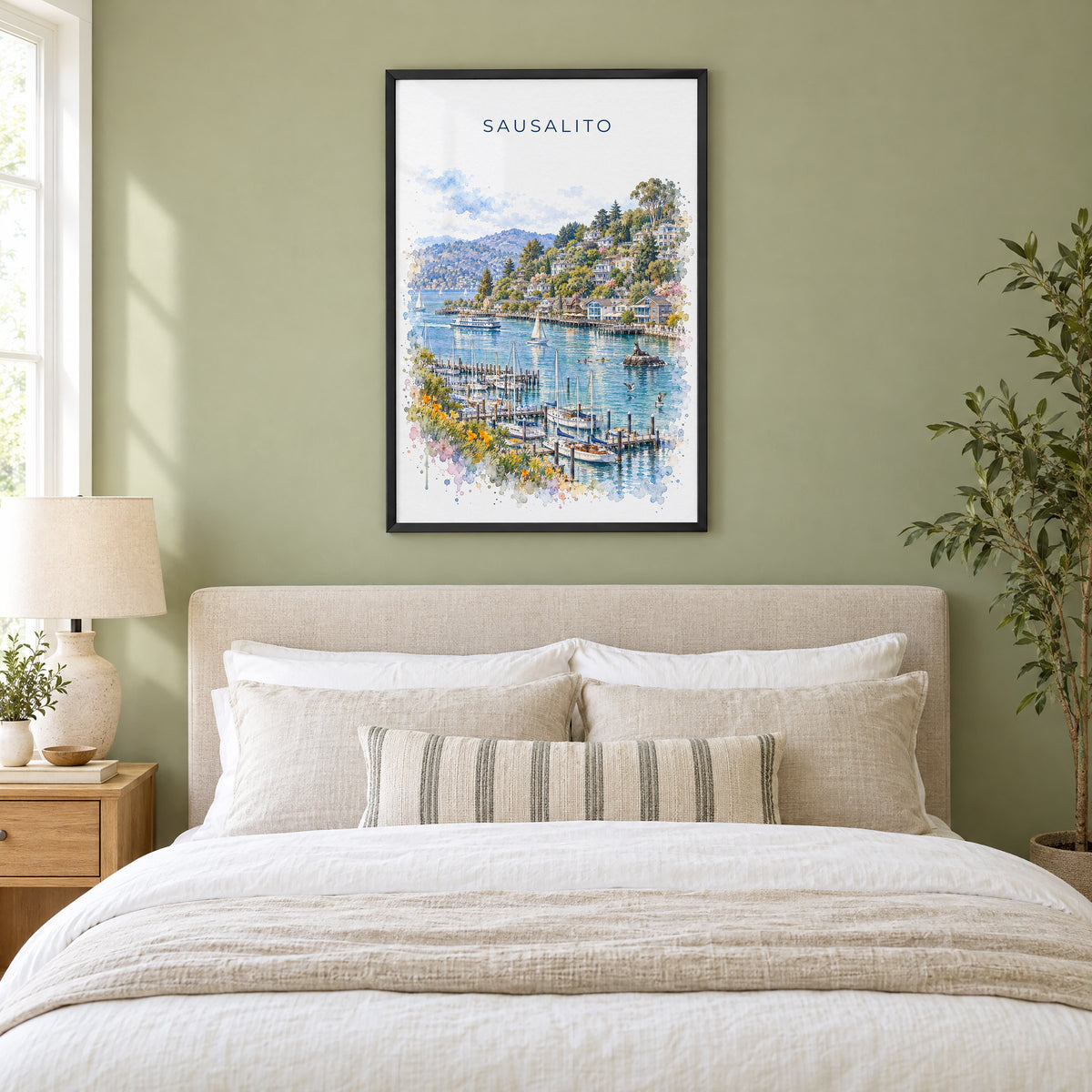 Sausalito watercolor print in a black frame above an upholstered headboard in a sage green bedroom