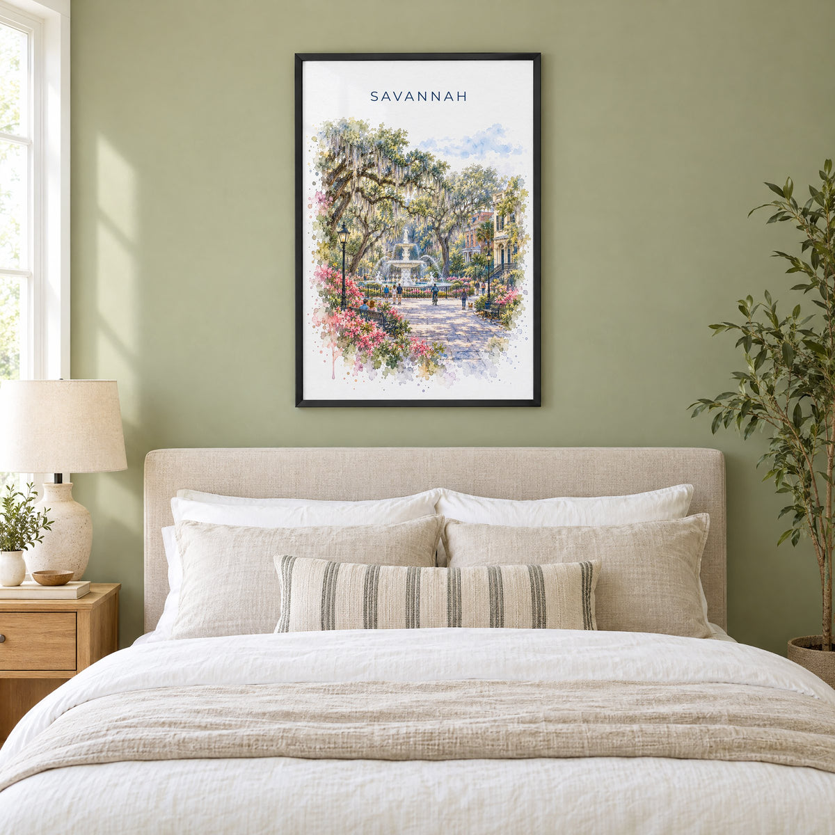 Savannah watercolor print in a black frame above an upholstered headboard in a sage green bedroom
