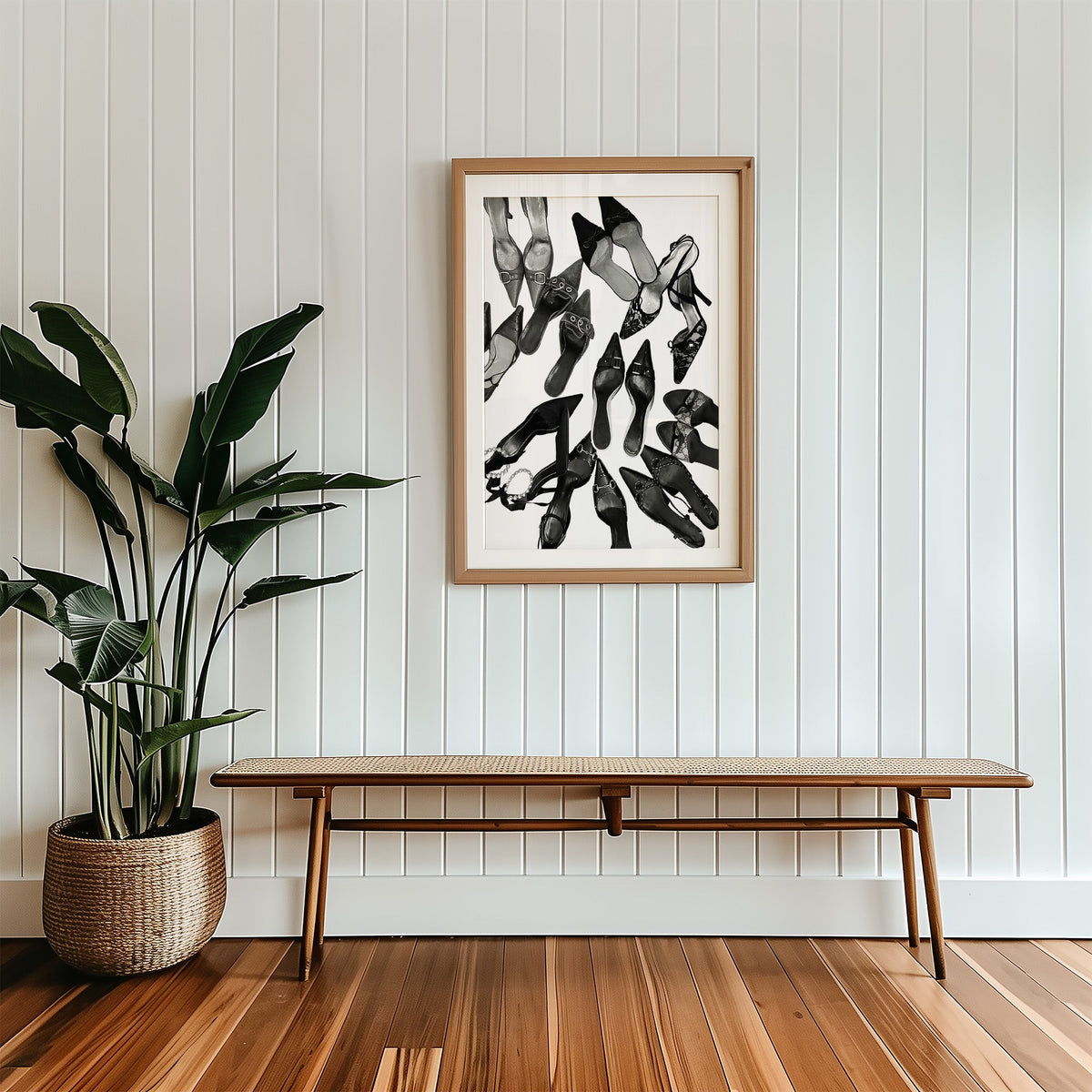 Top-down scattered pointed heels and mules print in a wood frame with a white mat above a cane bench