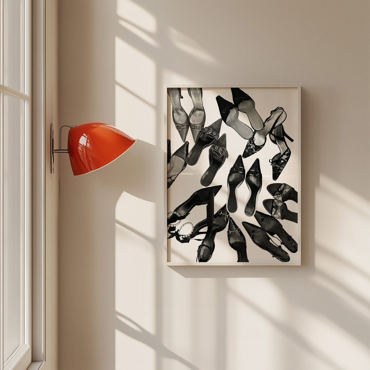Top-down scattered pointed heels and mules print in a white frame on a sunlit wall beside a red sconce