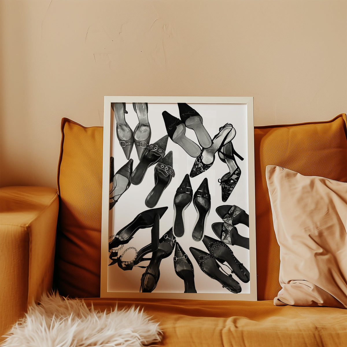 Top-down scattered pointed heels and mules print in a white frame leaning on a mustard velvet sofa