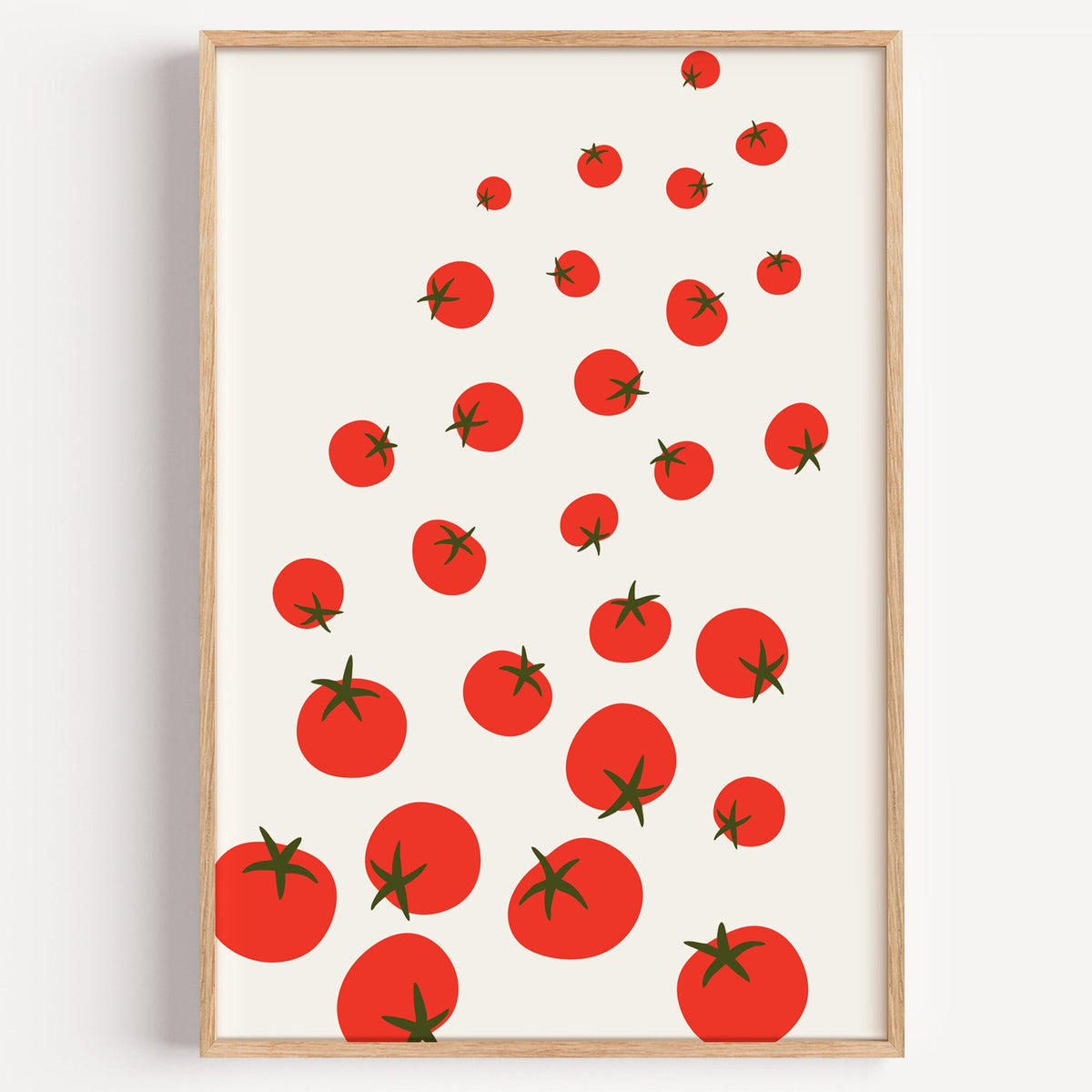 Scattered tomatoes print in a light oak frame on a plain white wall