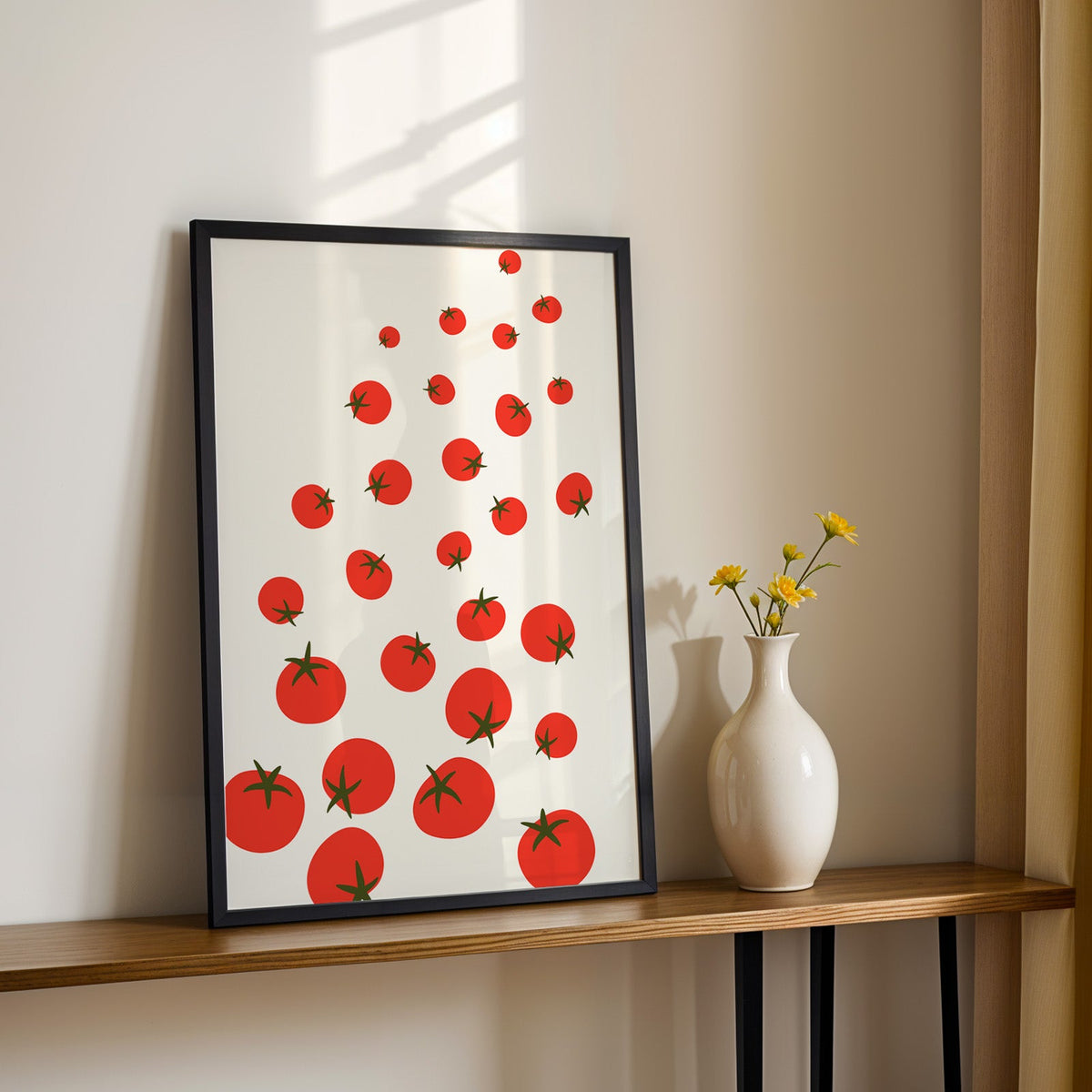 Scattered tomatoes print in a black frame on a console table with yellow daisies