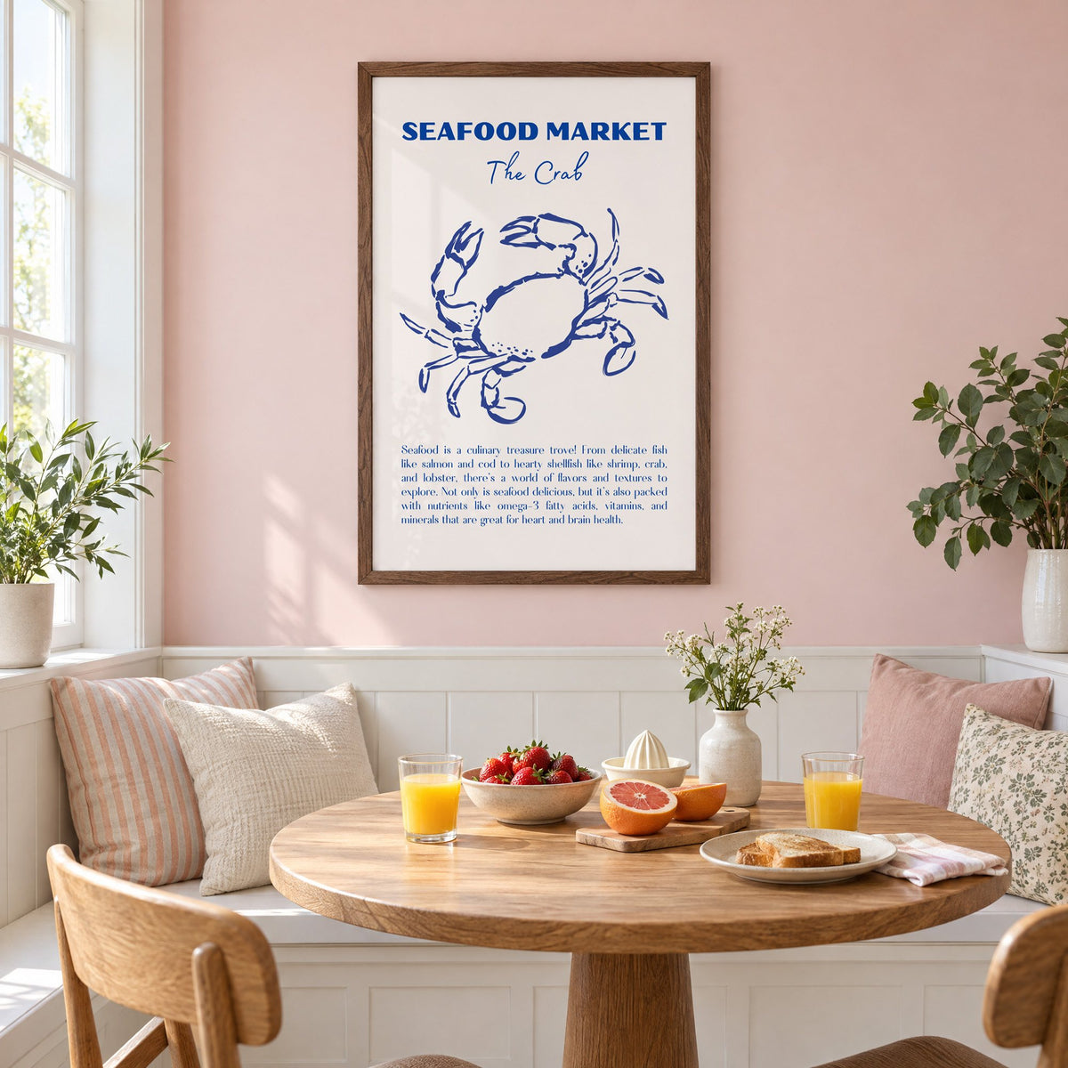 SEAFOOD MARKET The Crab cobalt sketch print in a walnut frame on a pastel pink wall above a breakfast nook with strawberries and orange juice