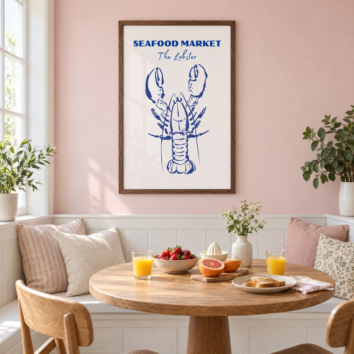 SEAFOOD MARKET The Lobster cobalt sketch print in a walnut frame on a pastel pink wall above a breakfast nook with strawberries and orange juice