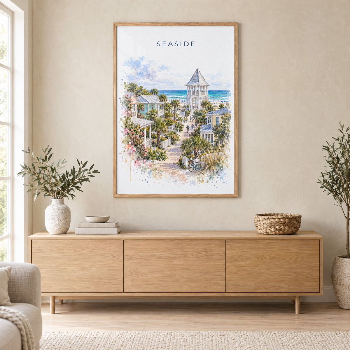 Seaside, Florida watercolor print in an oak frame above a light wood sideboard in a Scandinavian living room