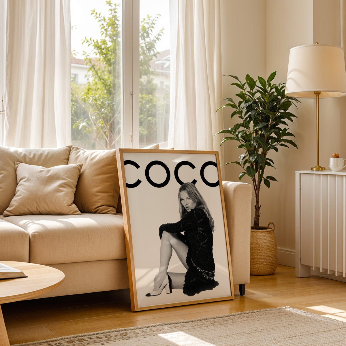 Seated woman in black knit dress under giant letters print in a light oak frame leaning on a cream sofa beside a floor lamp