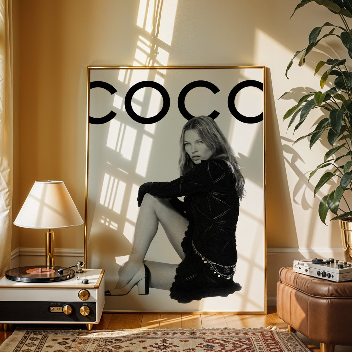 Seated woman in black knit dress under giant letters print shown in a gold frame beside a record player and table lamp