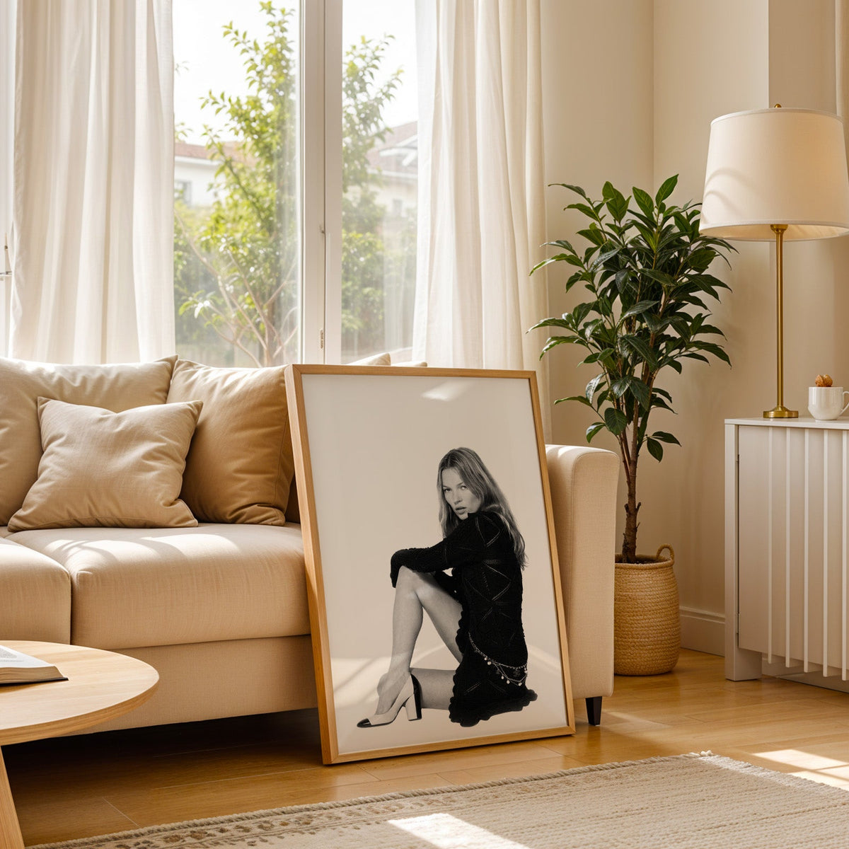 Seated woman in lace-pattern knit dress on white print in a light oak frame leaning on a cream sofa beside a floor lamp