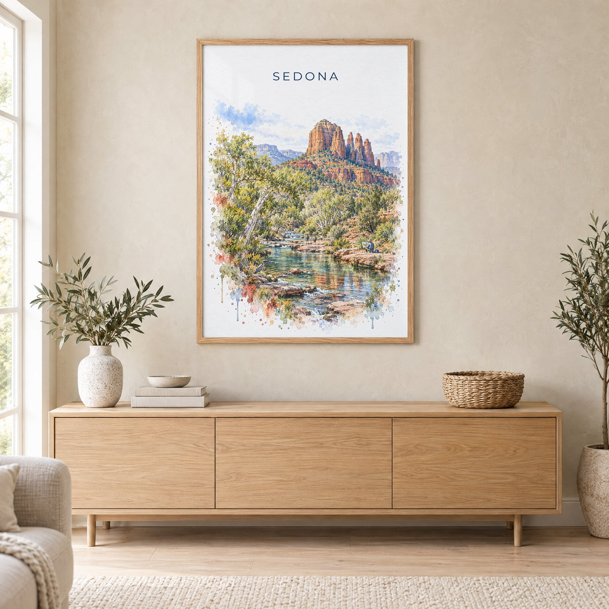 Sedona watercolor print in an oak frame above a light wood sideboard in a Scandinavian living room