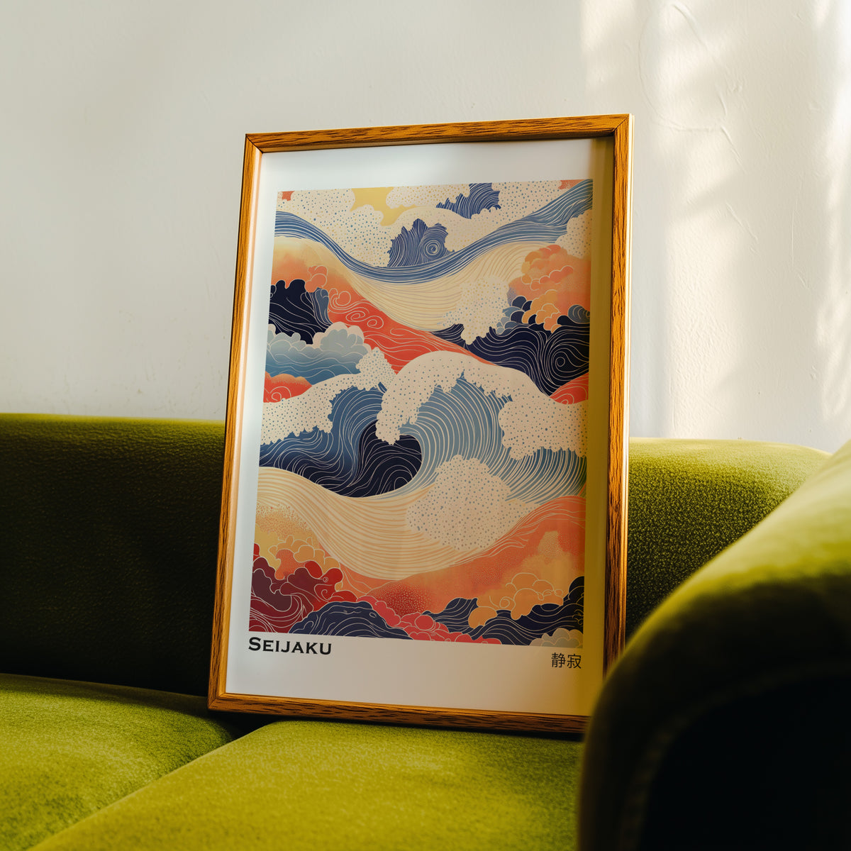 Orange and navy Seijaku waves print in an oak frame propped on a green velvet sofa
