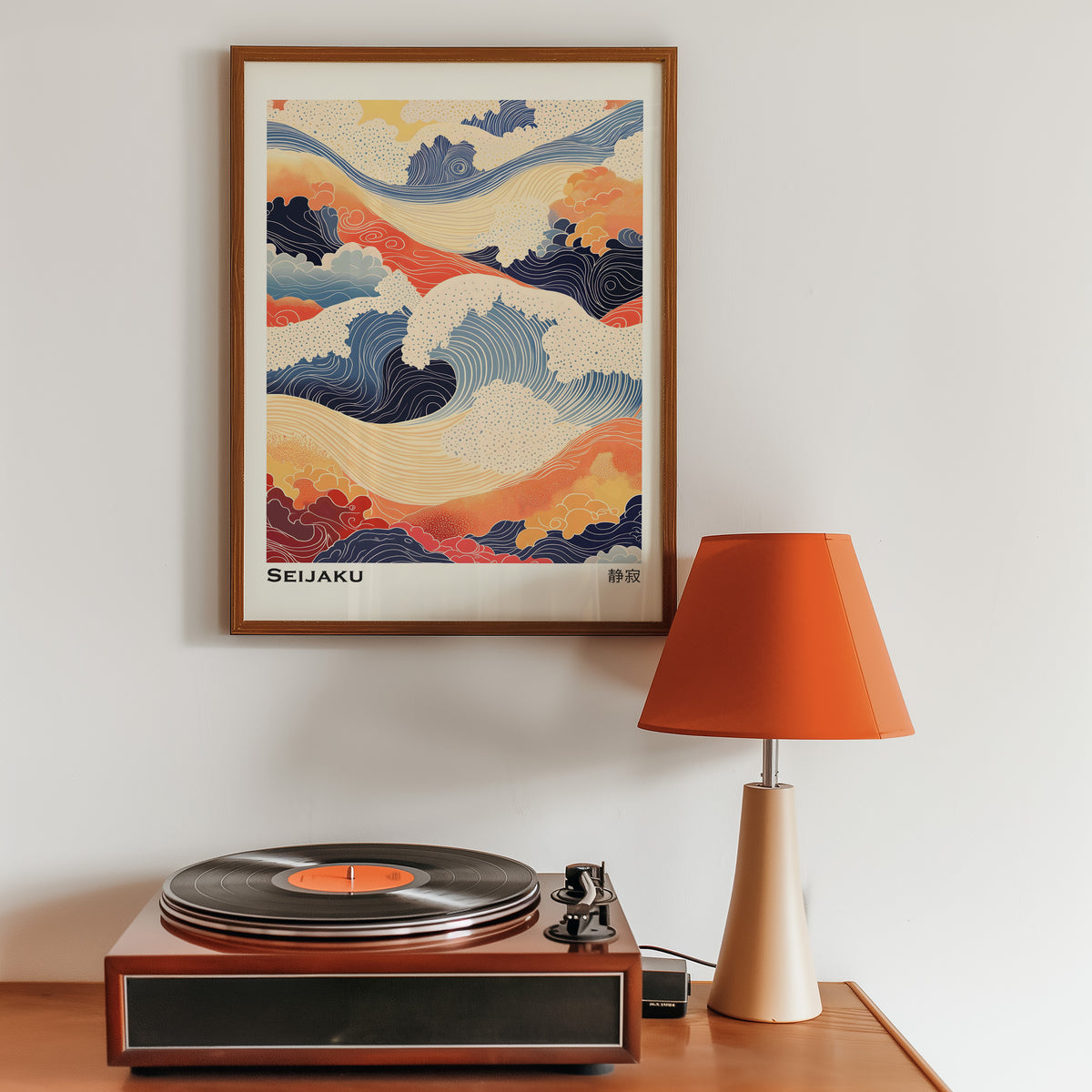 Orange and navy Seijaku waves print in a walnut frame above a sideboard with a record player