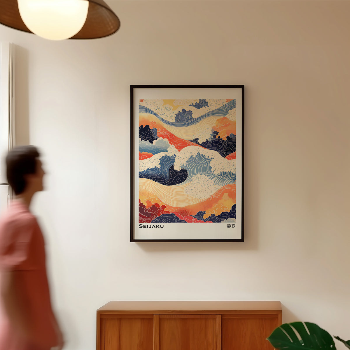 Orange and navy Seijaku waves print in a black frame in a hallway under a rattan pendant