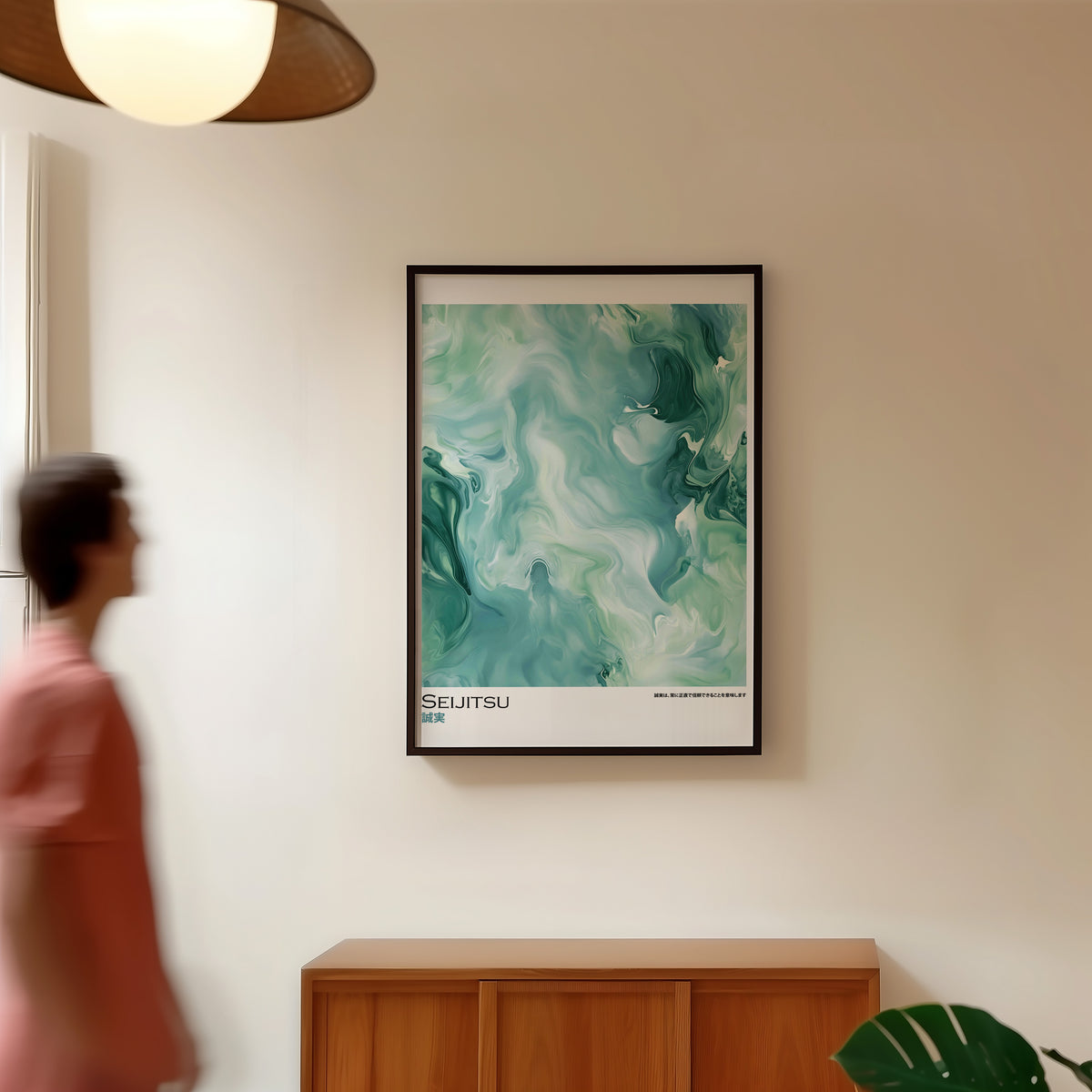 Teal and moss green marble print in a black frame in a hallway under a rattan pendant