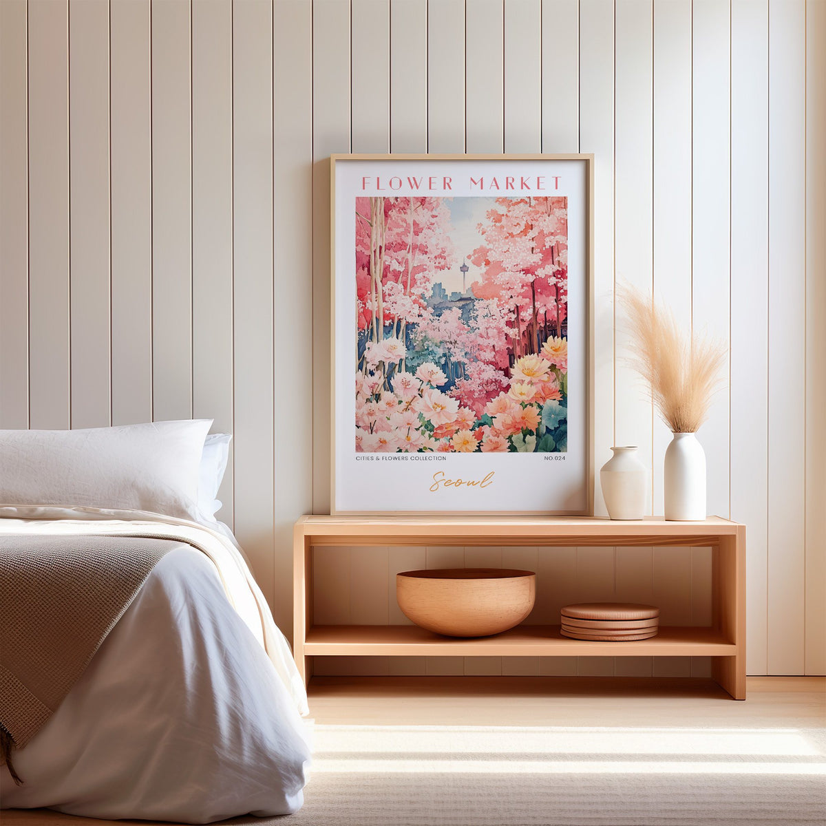 Seoul flower market print in an oak frame on a wood bench against a white shiplap bedroom wall with pampas grass