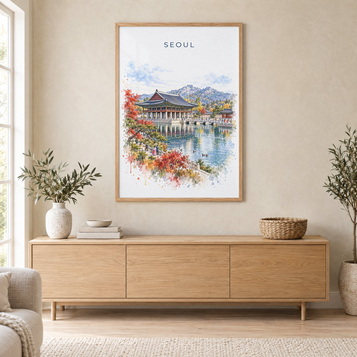 Seoul watercolor print in an oak frame above a light wood sideboard in a Scandinavian living room