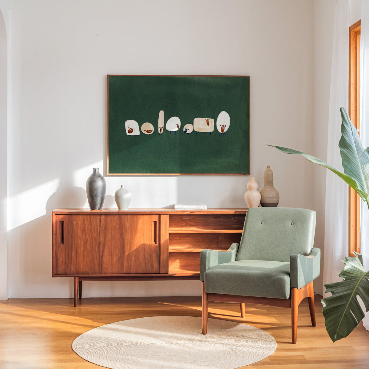 Whimsical flock print in a walnut frame above a sideboard beside a sage armchair