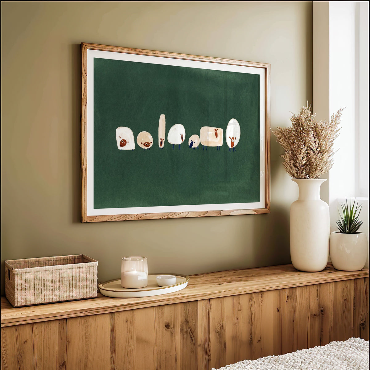 Seven quirky sheep print in an oak frame on an olive green wall above pampas grass
