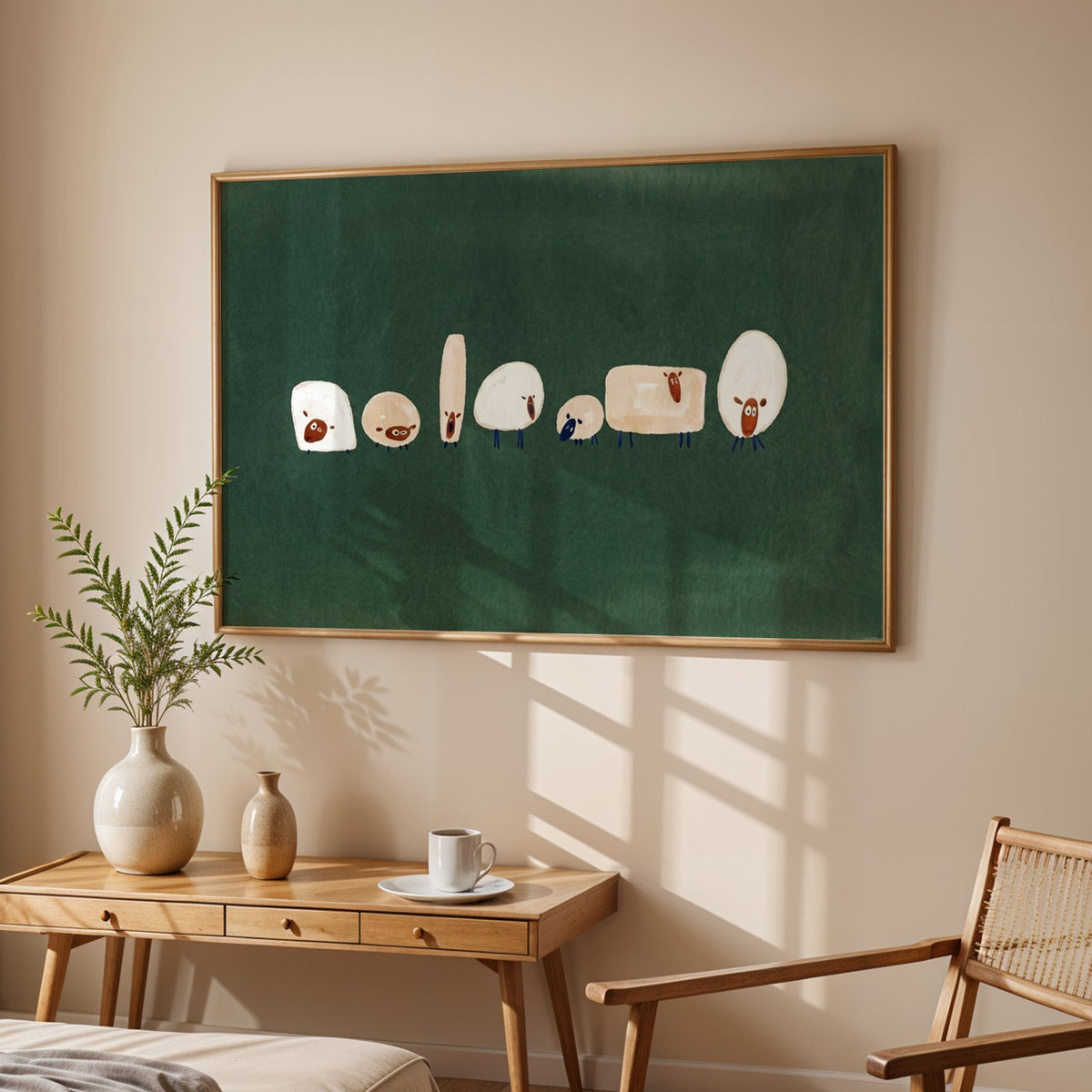 Green nursery sheep print in an oak frame above a sunlit desk with a cane chair