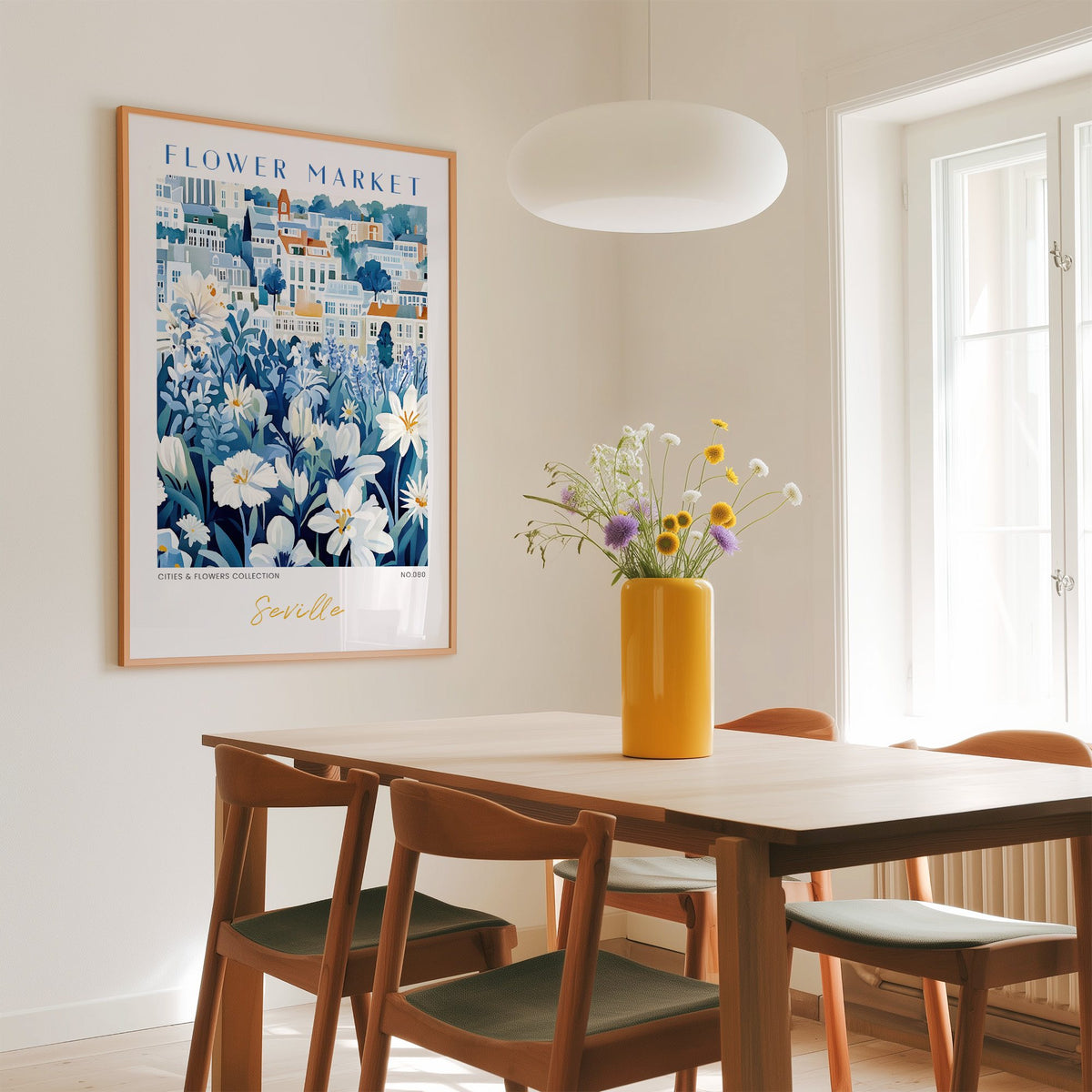 Seville flower market print in an oak frame above a dining table with a yellow vase and white pendant light