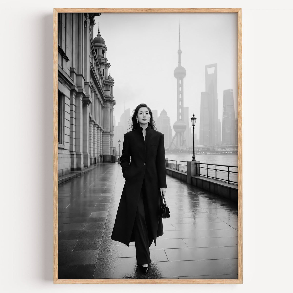 Black and white Shanghai Bund woman in black coat print in a light oak frame on a plain white wall