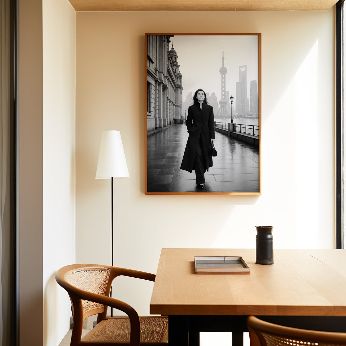 Black and white Shanghai Bund woman in black coat print in an oak frame above a dining table and cane chair