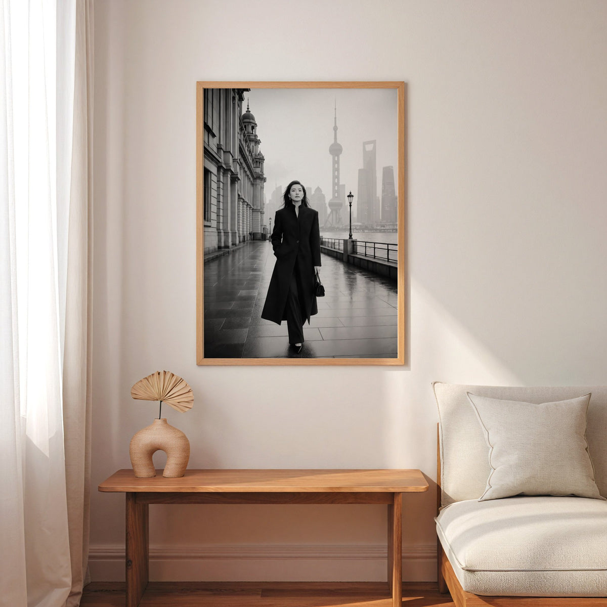 Black and white Shanghai Bund woman in black coat print in an oak frame above a narrow console with an arched vase
