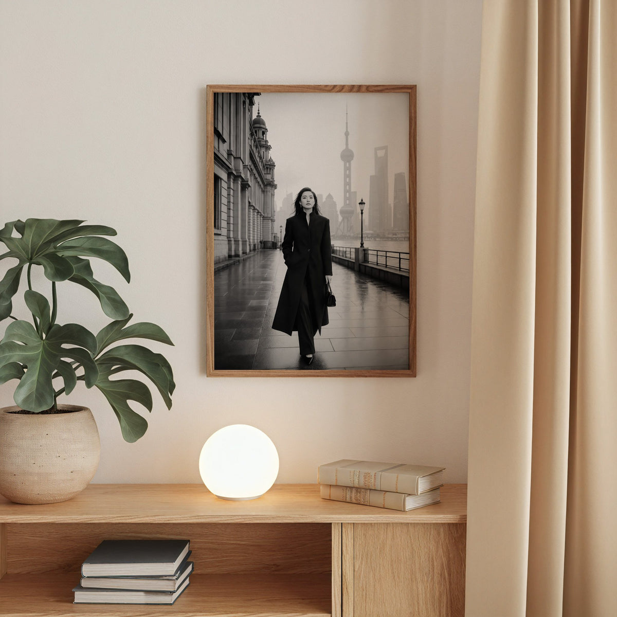 Black and white Shanghai Bund woman in black coat print in a walnut frame above an oak cabinet with a glowing globe lamp
