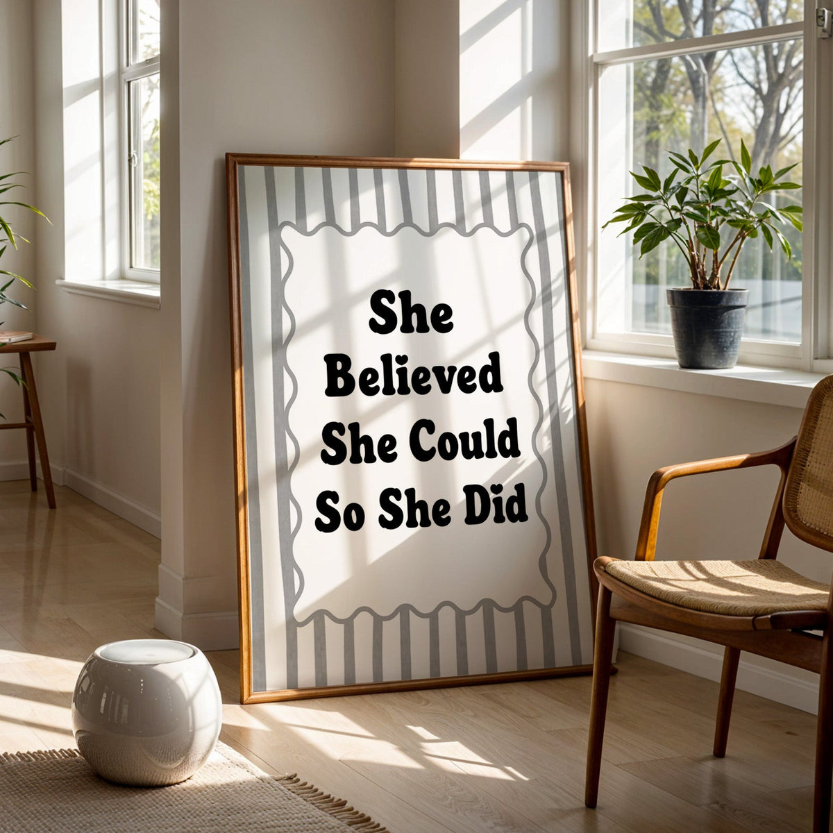 She believed she could so she did striped quote print in a walnut frame on a wood floor beside a cane chair and sunny window