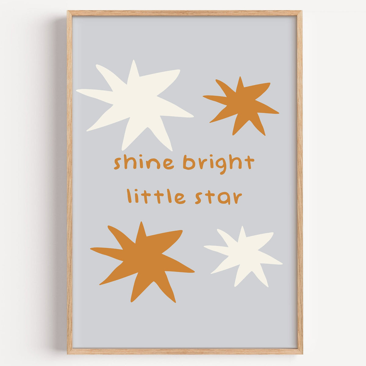 Shine bright little star nursery print in a light oak frame on a plain white wall