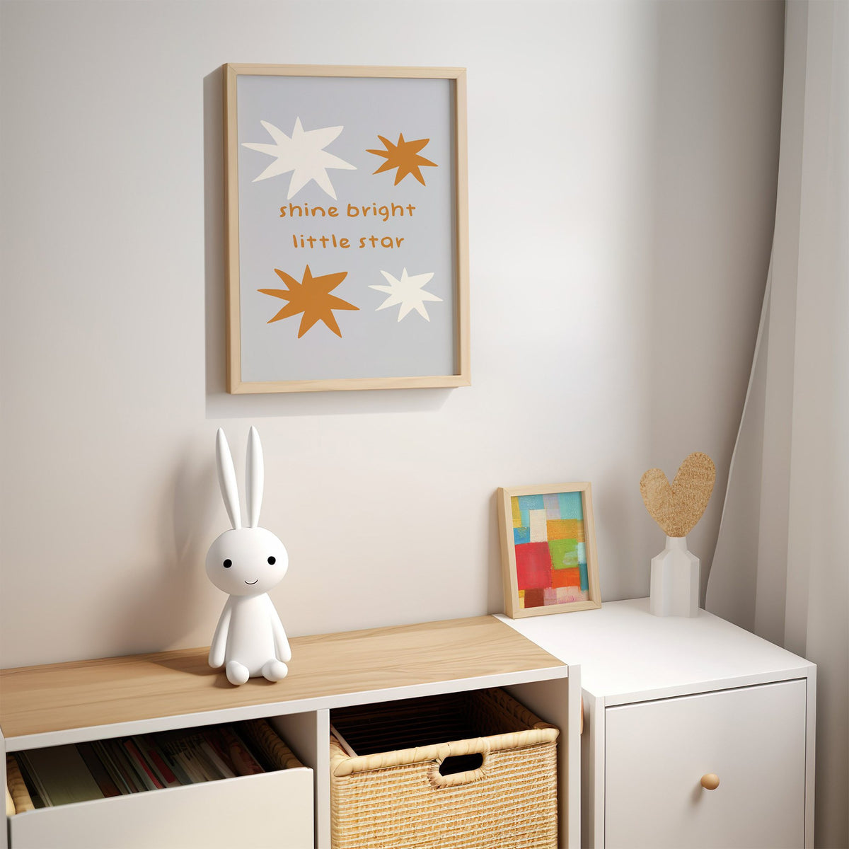 Shine bright little star nursery print in an oak frame above a kids cubby shelf with a woven basket and bunny lamp