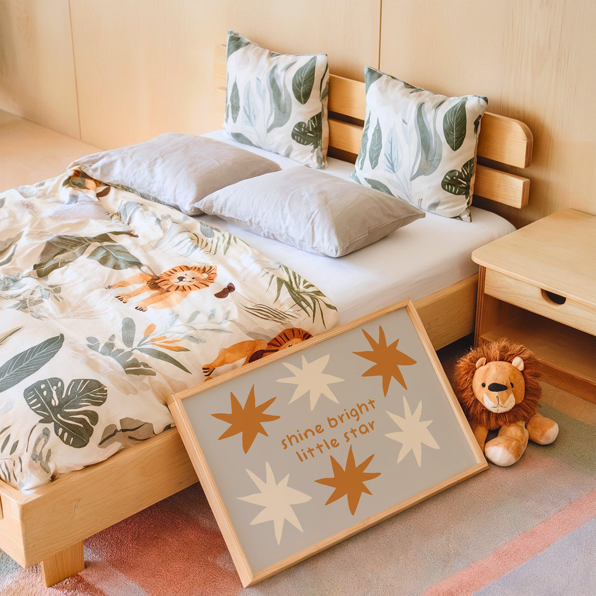 Landscape shine bright little star nursery print in an oak frame leaning on a kids bed by a lion plush
