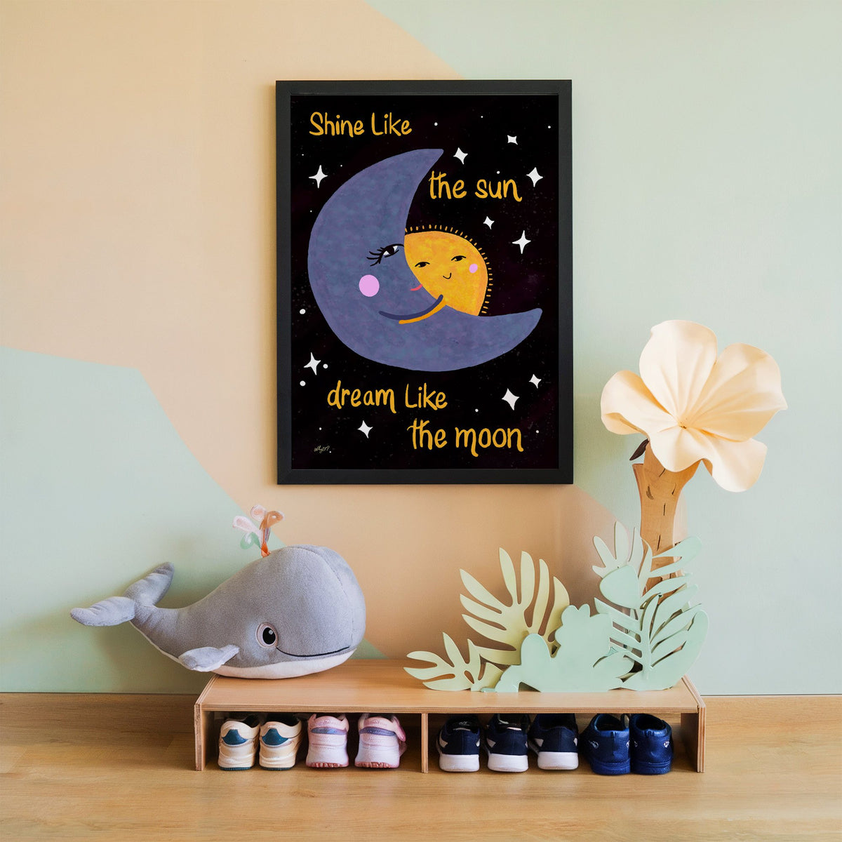 Moon hugging sun quote nursery print in a black frame on a mint and peach wall above a whale plush
