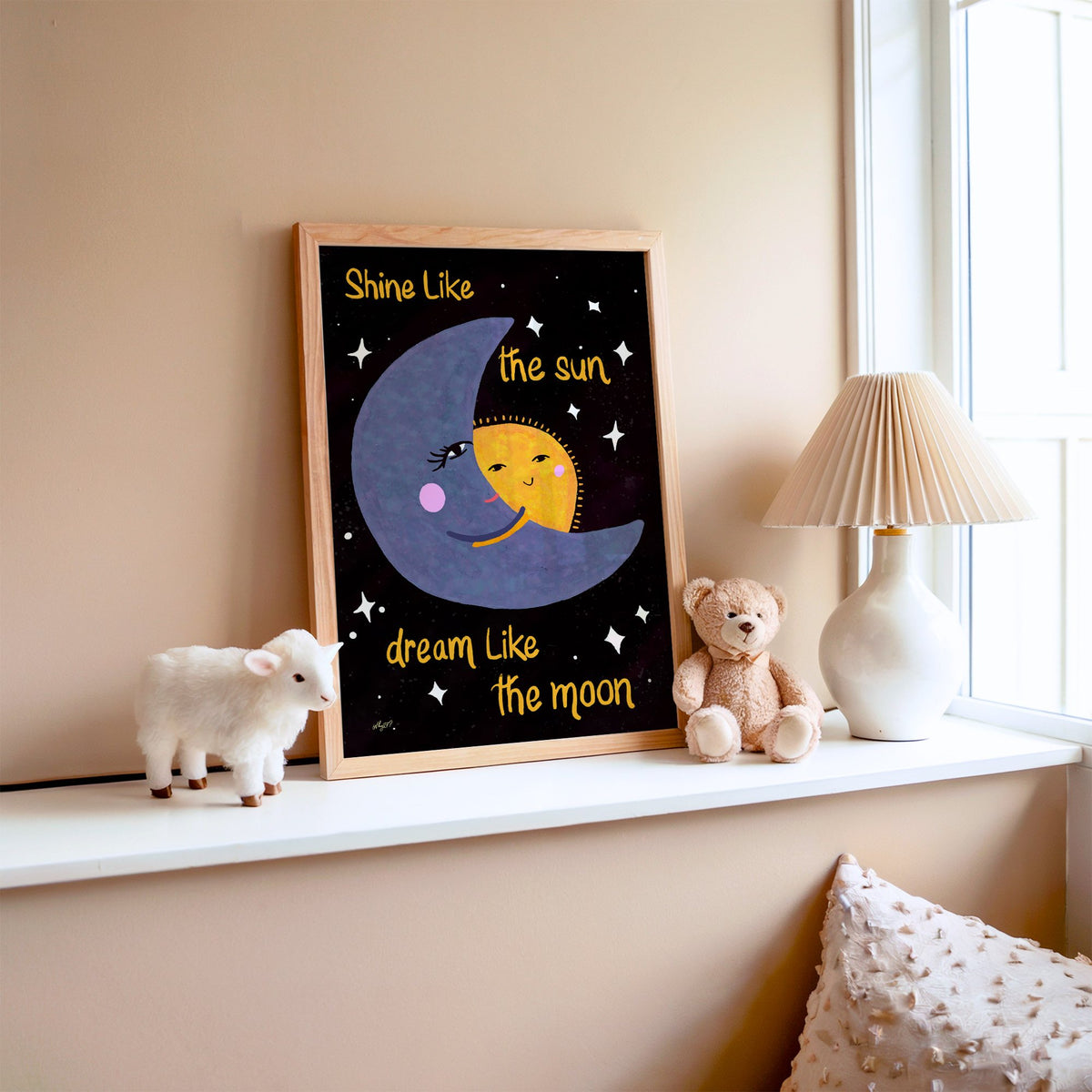 Moon hugging sun quote nursery print in an oak frame on a window ledge with a toy lamb and teddy