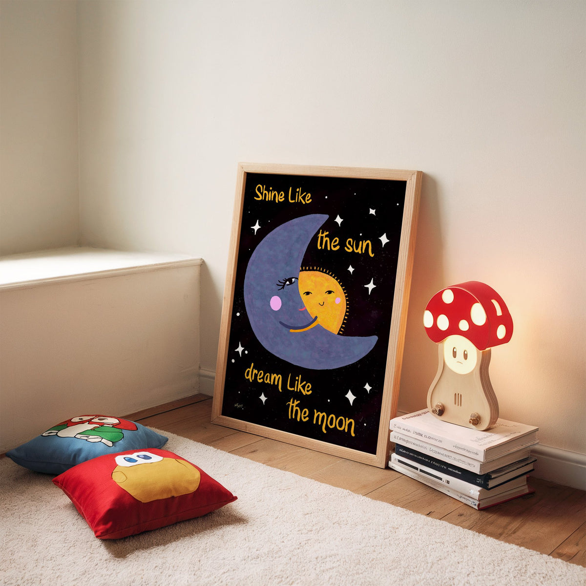 Moon hugging sun quote nursery print in an oak frame leaning on a rug beside a mushroom lamp and floor cushions