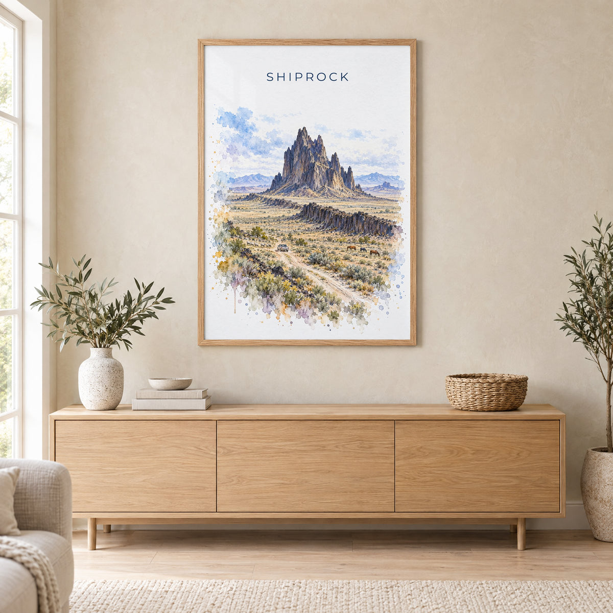 Shiprock watercolor print in an oak frame above a light wood sideboard in a Scandinavian living room