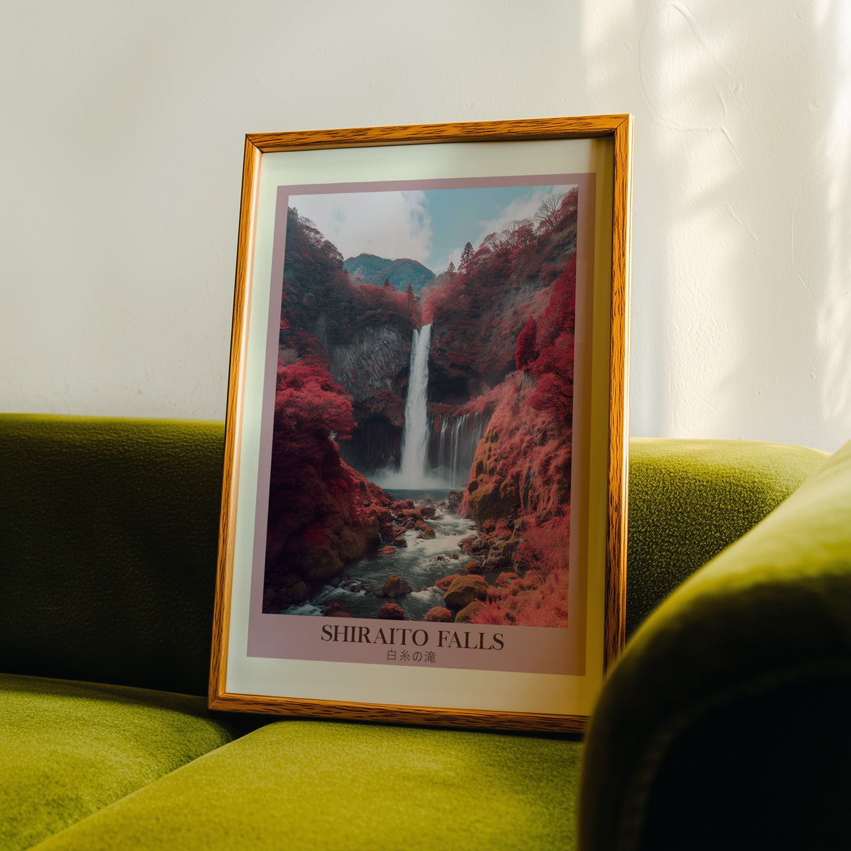Shiraito Falls in autumn print in an oak frame propped on a green velvet sofa