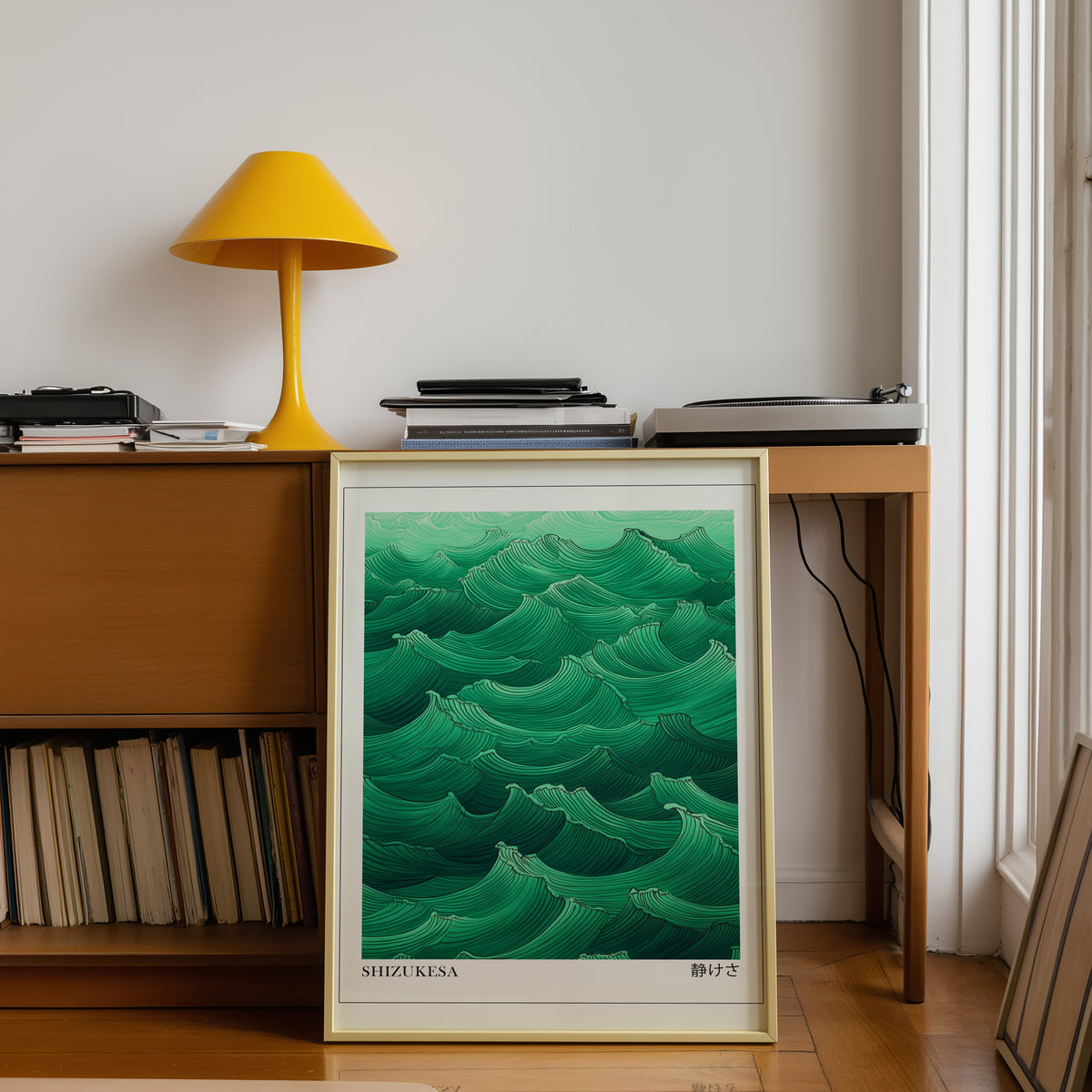 Jade green Shizukesa waves print shown in a gold frame below a teak desk with a yellow lamp