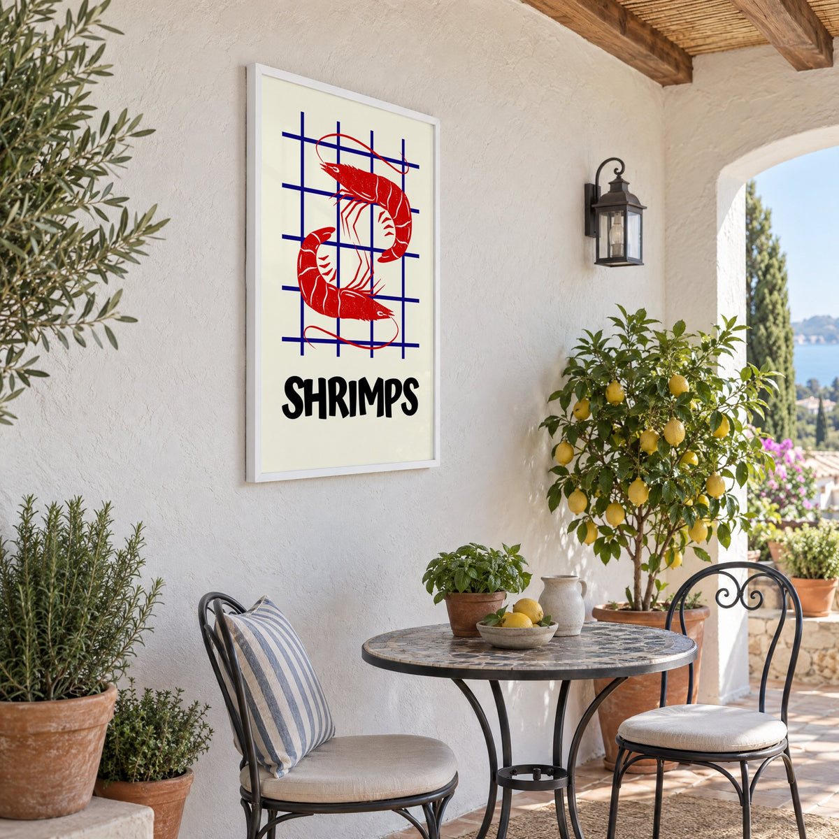 SHRIMPS red and blue grid print in a white frame on a sunny patio wall beside a potted lemon tree