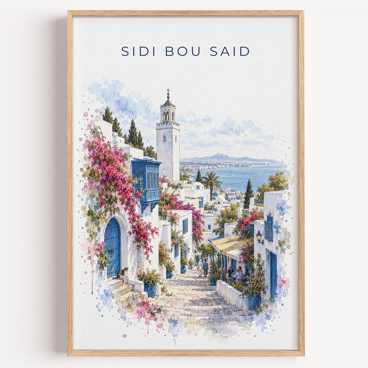 Sidi Bou Said watercolor print in a light oak frame on a plain white wall